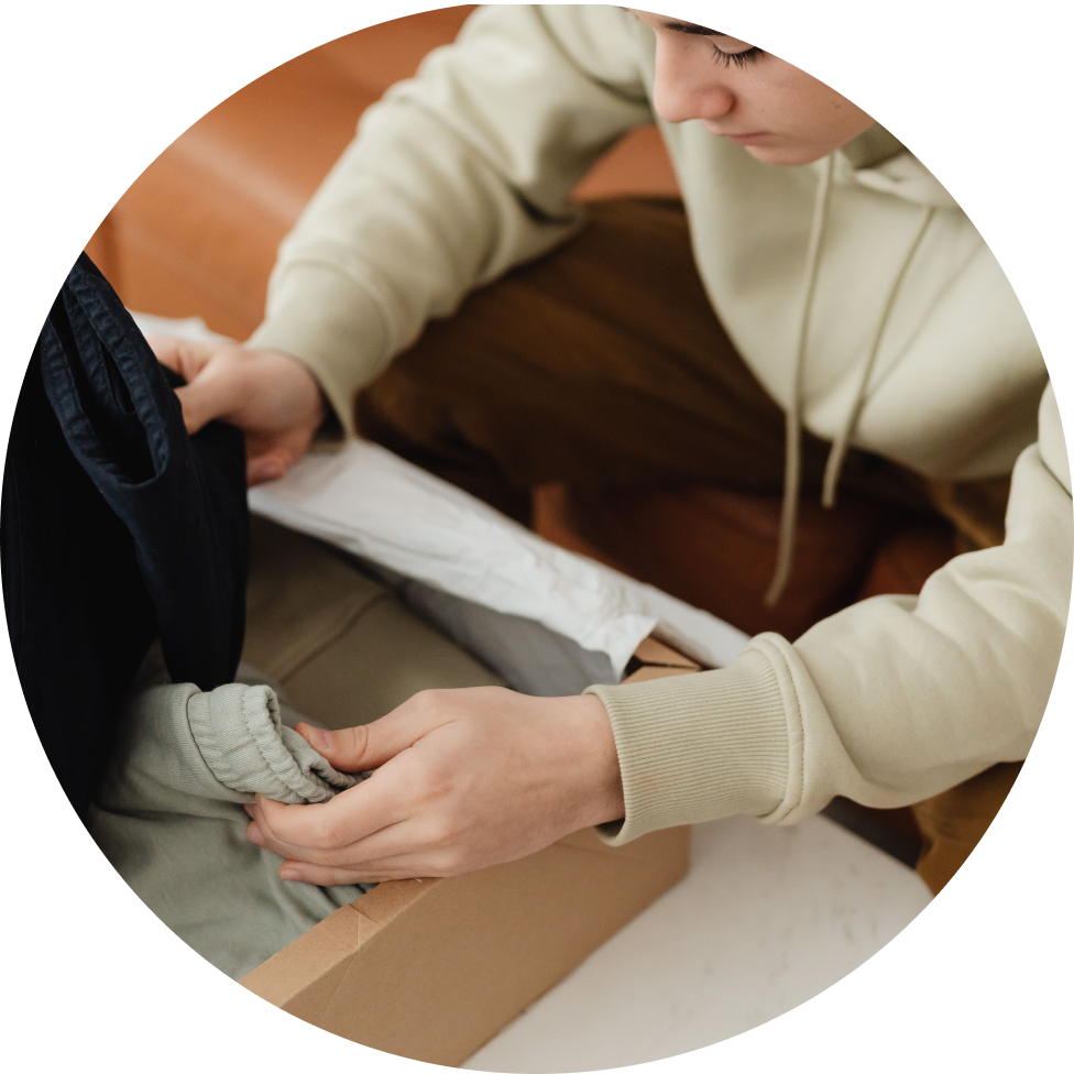 Person packing clothes into a box