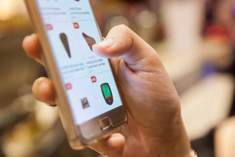 A closeup photo of someone doing mobile shopping and tapping a product on their phone