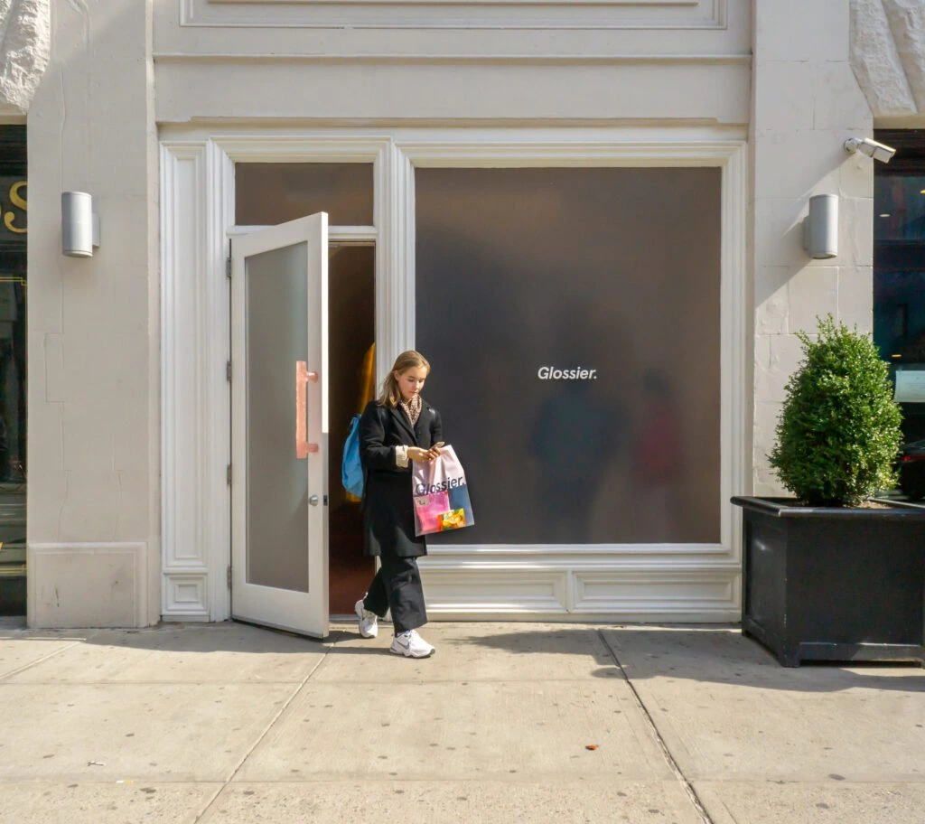 A woman walks out of luxury beauty store Glossier