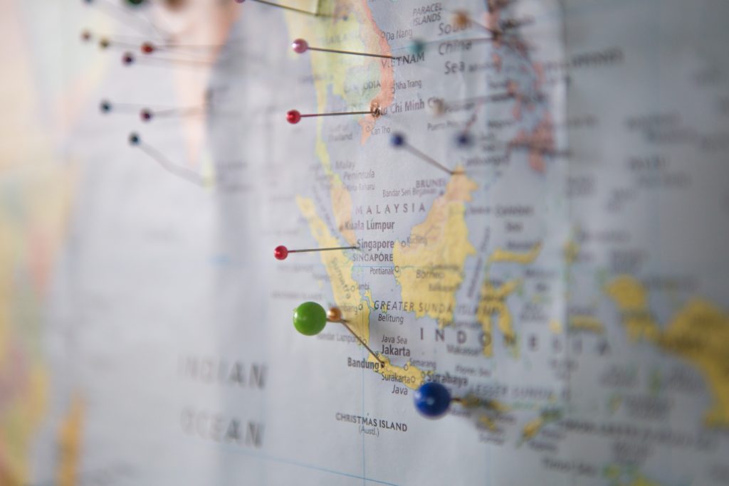 close up of a map with pushpins in multiple South East Asian countries