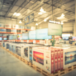A blurred photo of television inventory on pallets in a warehouse