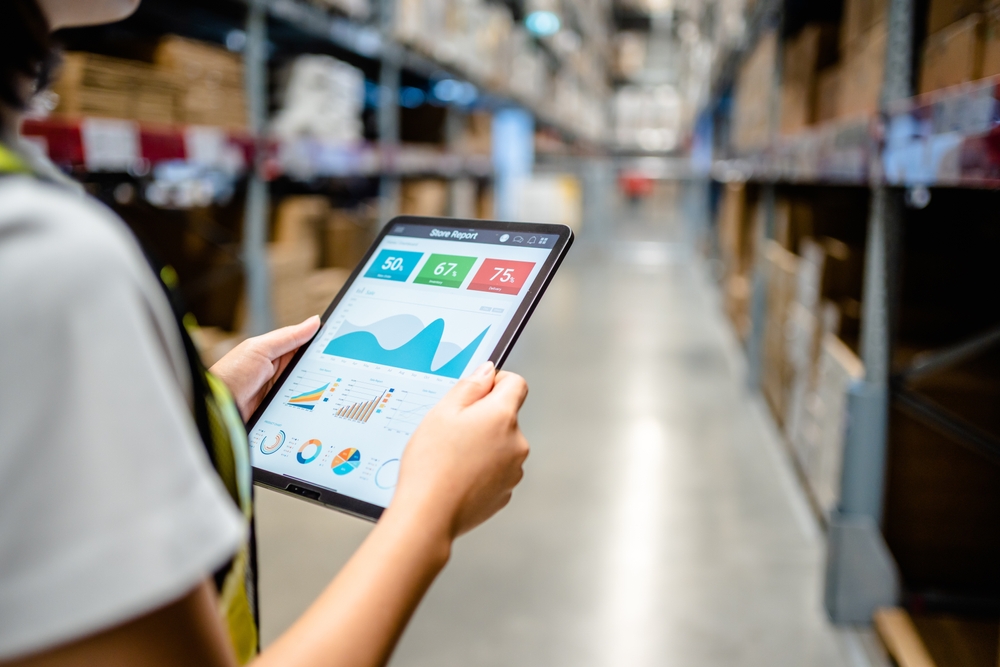 A woman looks at an inventory management solution in a warehouse and shipping facility