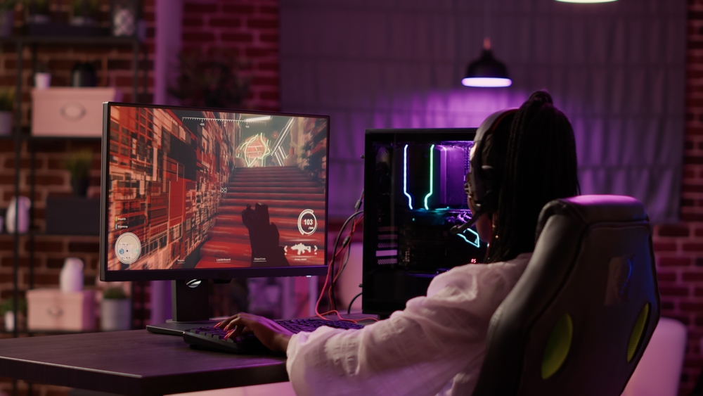 over the shoulder view of a young woman playing computer games