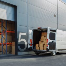 A last-mile delivery van sits outside a warehouse