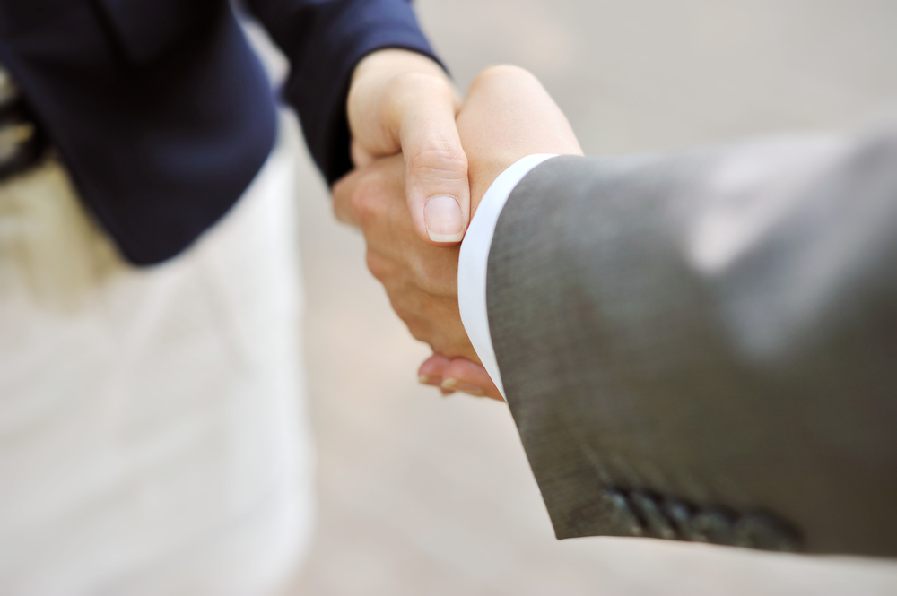 A businessman and businesswoman shake hands